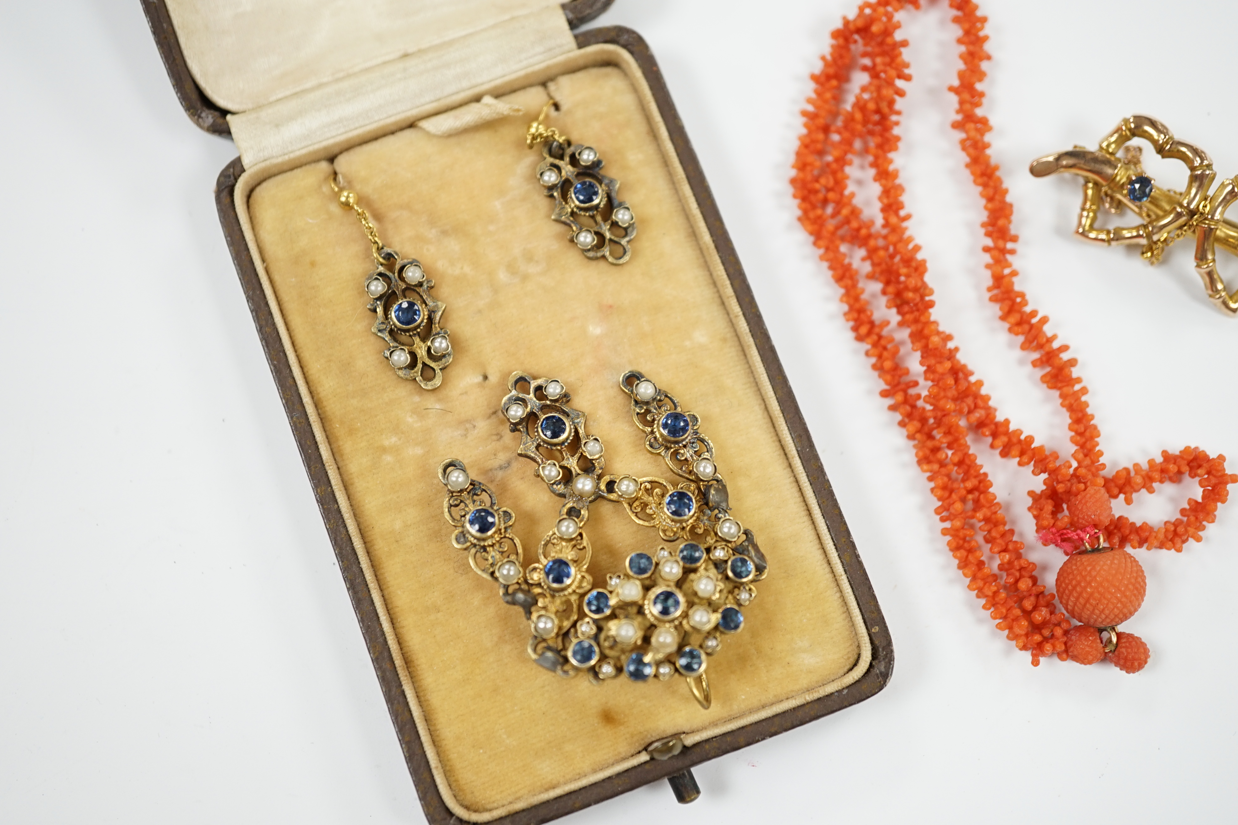 A suite of gilt metal and paste set jewellery, comprising a necklace and pair of earrings, a late Victorian 9ct gold and two stone sapphire set twin hearts brooch and a coral necklace.